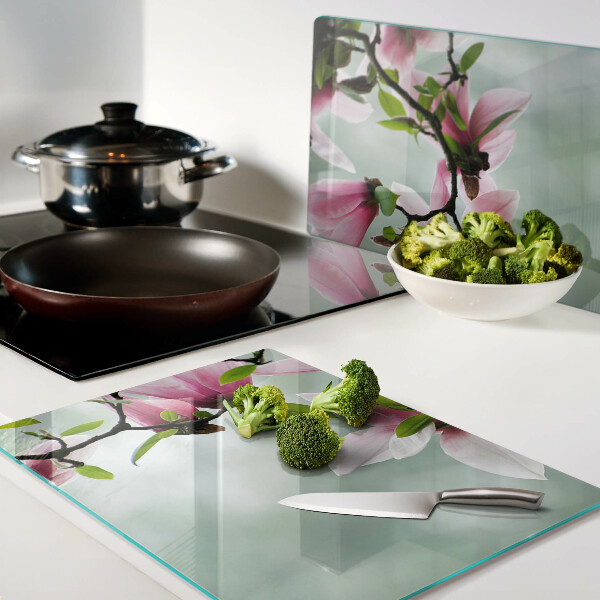 Schneidebrett mit Motiv aus Magnolienblüten vor grünem Hintergrund