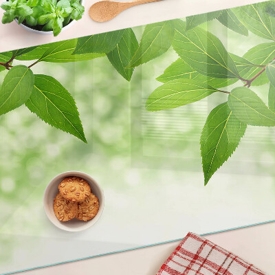 Glas schneidebrett Blätter vor einem verschwommenen grünen Hintergrund