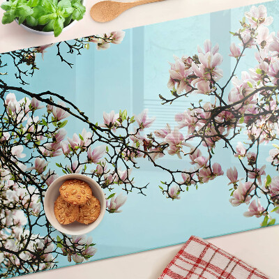 Glas schneidebrett Magnolienblüten auf blauem Hintergrund