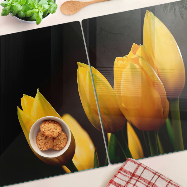 Schneidebrett mit gelben Tulpen auf schwarzem Hintergrund