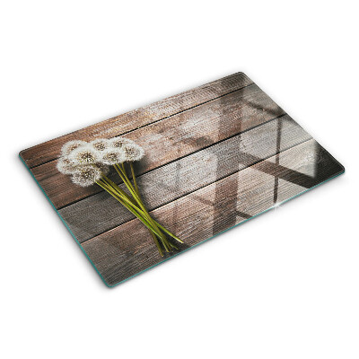 Schneidebrett glas Löwenzahnblüten auf Holzgrund