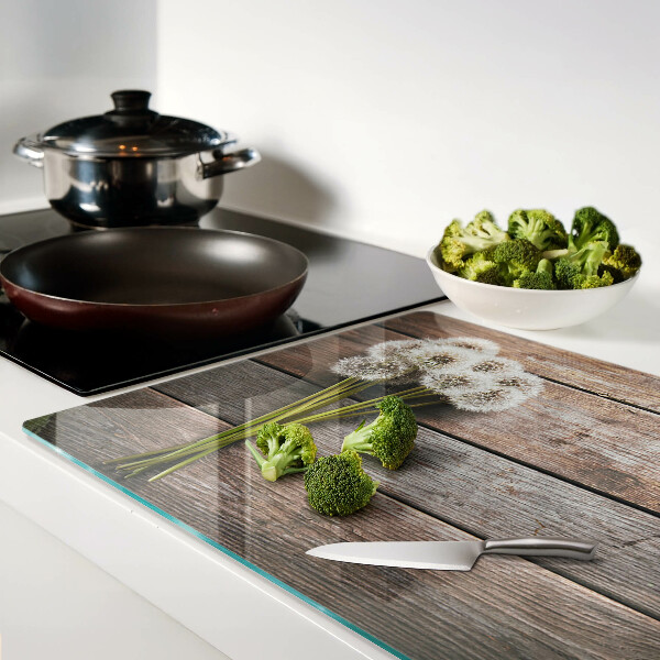 Schneidebrett glas Löwenzahnblüten auf Holzgrund