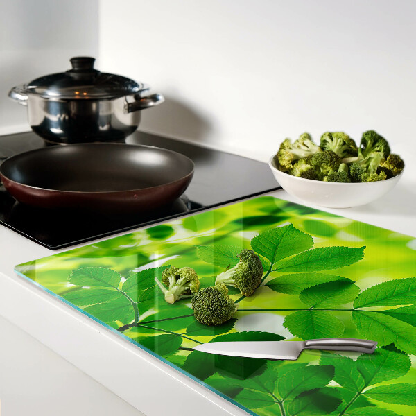 Schneidebrett mit Muster aus Blättern auf grünem Hintergrund