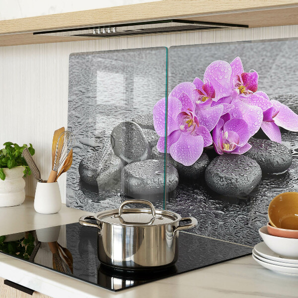 Schneidebrett mit Blumen- und Steindekor vor Wasserhintergrund