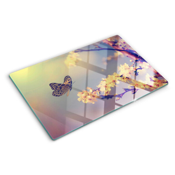 Schneidebrett Glas mit Schmetterlingsmotiv vor Blumenhintergrund