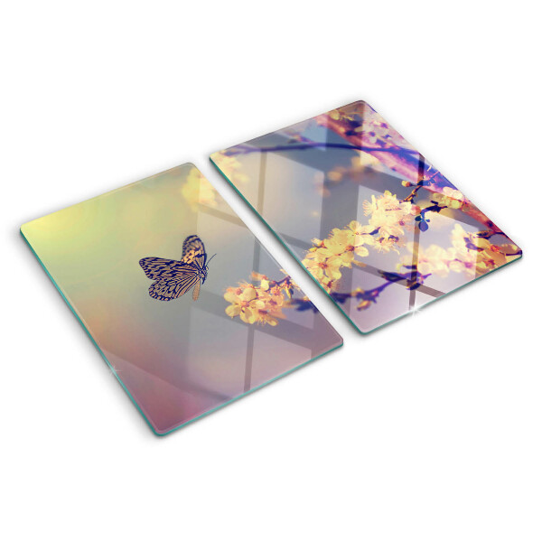 Schneidebrett Glas mit Schmetterlingsmotiv vor Blumenhintergrund