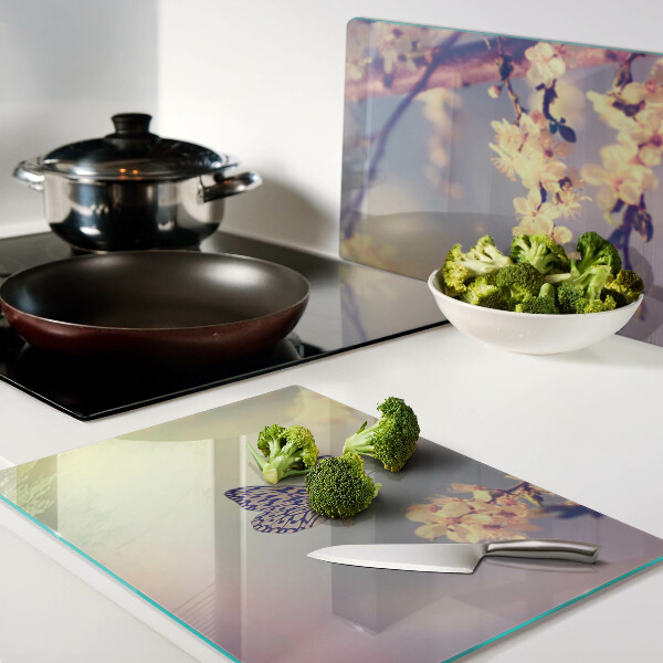 Schneidebrett Glas mit Schmetterlingsmotiv vor Blumenhintergrund