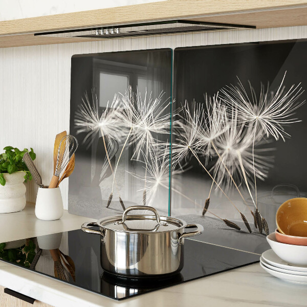 Glas Schneidebrett mit flauschigen Löwenzahnblüten auf einfarbigem Hintergrund