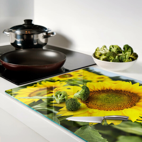 Schneidebrett glas Sonnenblumen vor grünem Hintergrund