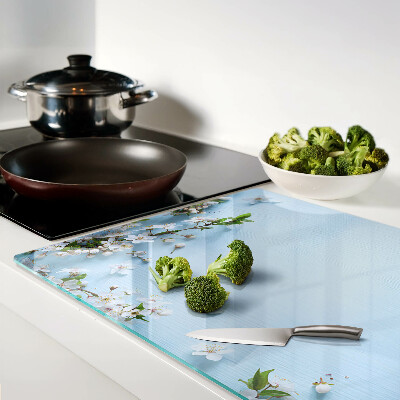 Glas-Schneidebrett mit Blumenmuster auf blauem Hintergrund