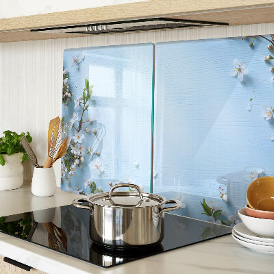 Glas-Schneidebrett mit Blumenmuster auf blauem Hintergrund