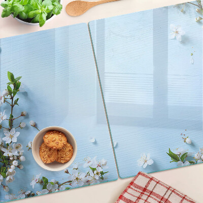 Glas-Schneidebrett mit Blumenmuster auf blauem Hintergrund