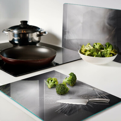 Schneidebrett Glas mit Motiv flauschiger Löwenzahnblüten vor einem Fensterhintergrund