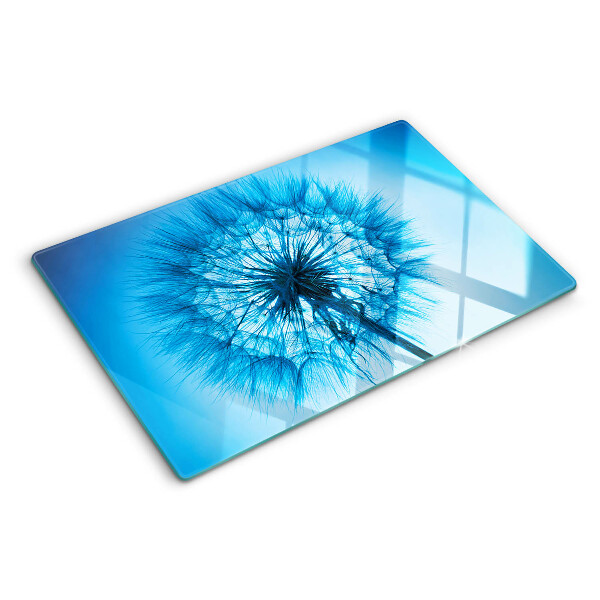 Glas-Schneidebrett mit Löwenzahn-Motiv auf blauem Hintergrund
