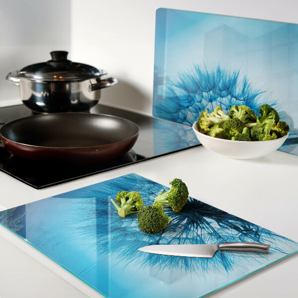 Glas schneidebrett Löwenzahn auf blauem Hintergrund