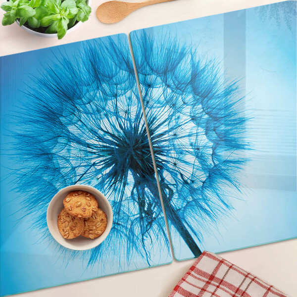 Glas-Schneidebrett mit Löwenzahn-Motiv auf blauem Hintergrund