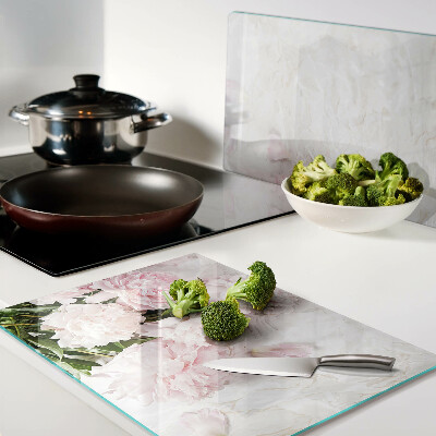 Glas-Schneidebrett mit Pfingstrosen auf marmoriertem Hintergrund