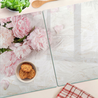 Glas-Schneidebrett mit Pfingstrosen auf marmoriertem Hintergrund