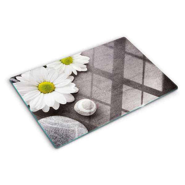Schneidebrett Glas mit Blumen- und Steinemotiv im Hintergrund