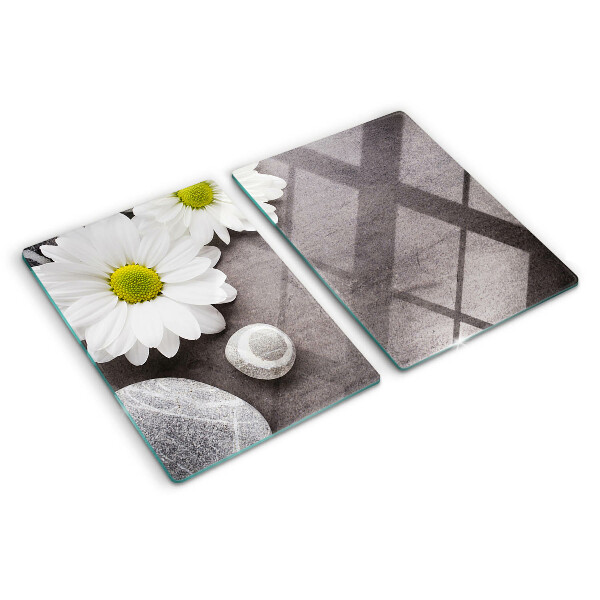 Schneidebrett Glas mit Blumen- und Steinemotiv im Hintergrund