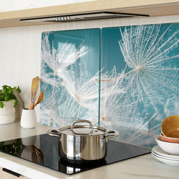 Glas-Schneidebrett mit Löwenzahn-Motiv auf blauem Hintergrund