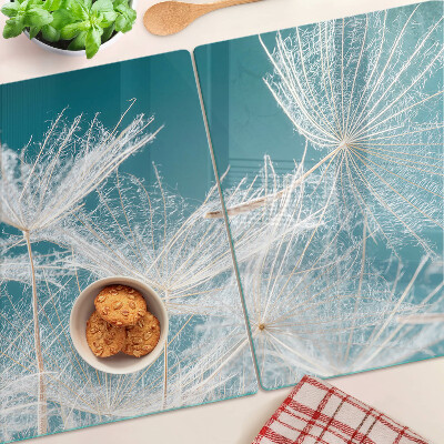 Glas-Schneidebrett mit Löwenzahn-Motiv auf blauem Hintergrund