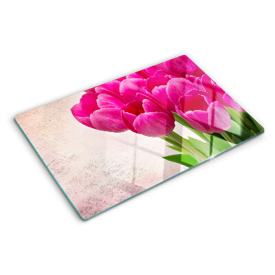 Schneidebrett Glas mit Tulpenblüten auf rosa Hintergrund
