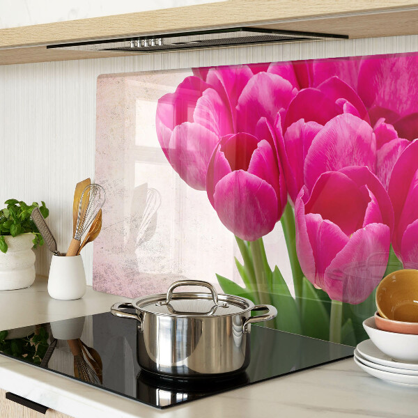Schneidebrett Glas mit Tulpenblüten auf rosa Hintergrund