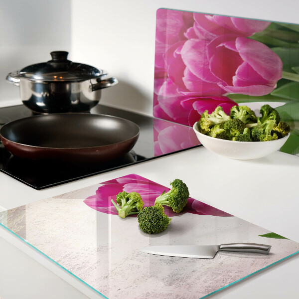 Schneidebrett glas Tulpenblüten auf rosa Hintergrund