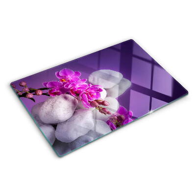 Schneidebrett Orchideenblüten vor einem steinernen Hintergrund