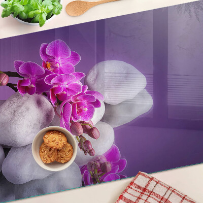Schneidebrett Orchideenblüten vor einem steinernen Hintergrund