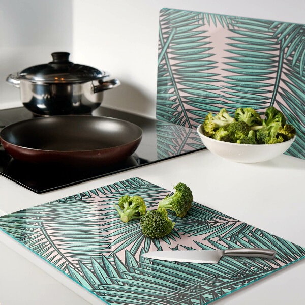 Glas Schneidebrett mit Palmenblättern auf rosa Hintergrund