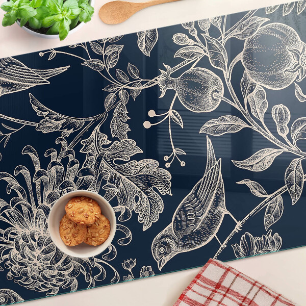 Schneidebrett mit Blumen- und Vogelmotiv auf dunklem Hintergrund