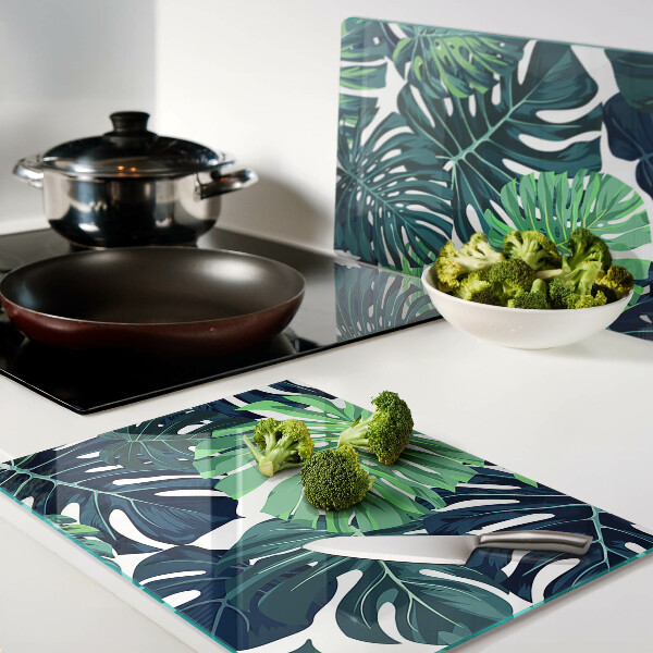 Schneidebrett glas Monstera-Blätter vor tropischem Hintergrund