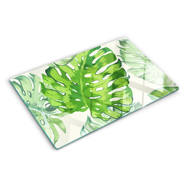 Schneidebrett mit Monstera-Blättern auf hellem Hintergrund