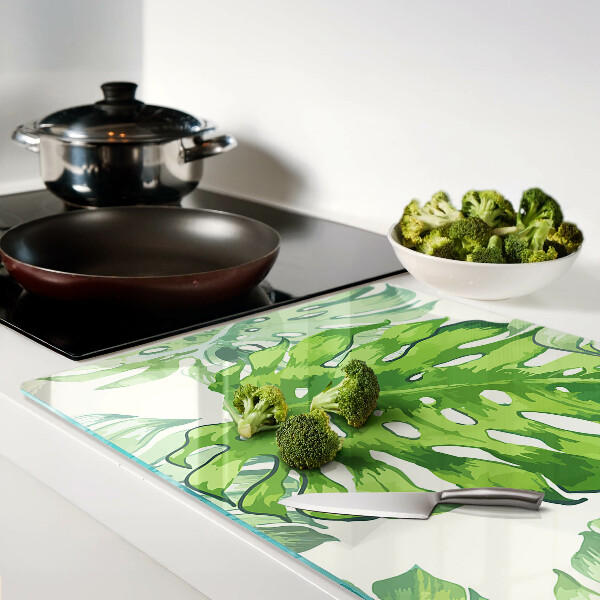 Schneidebrett mit Monstera-Blättern auf hellem Hintergrund