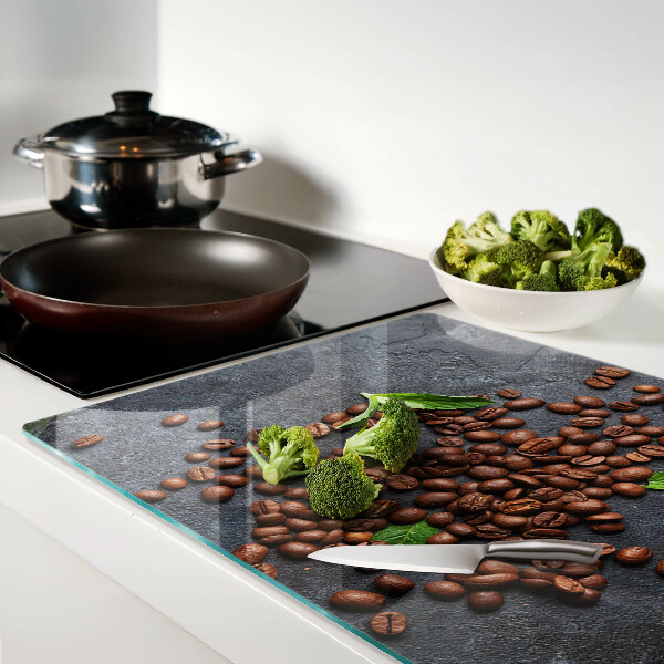 Glas-Schneidebrett mit Motiv aus Kaffeebohnen auf steinernem Hintergrund