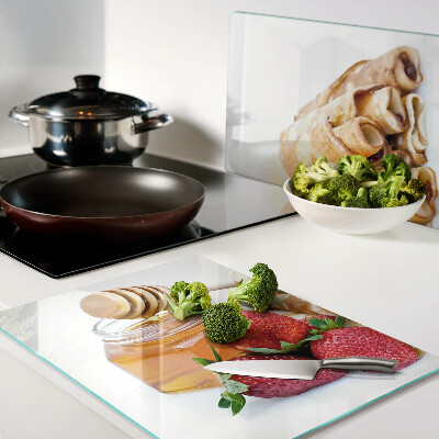 Glas schneidebrett Pfannkuchen mit Honig und Erdbeeren