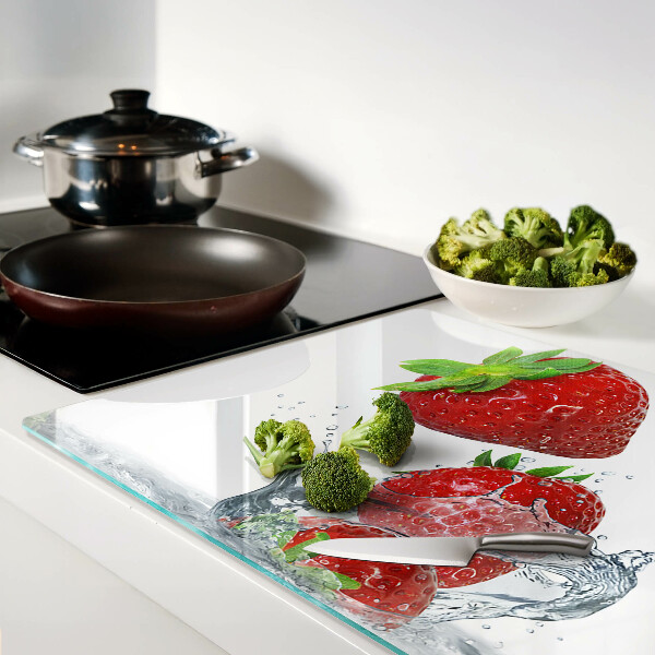 Glas Schneidebrett mit Erdbeeren unter Wasser als Motiv
