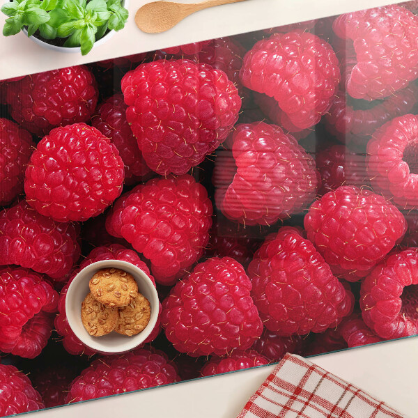 Schneidebrett glas Himbeeren im Hintergrund