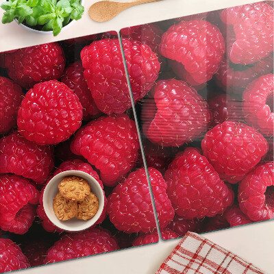 Schneidebrett Glas mit Himbeeren im Hintergrund