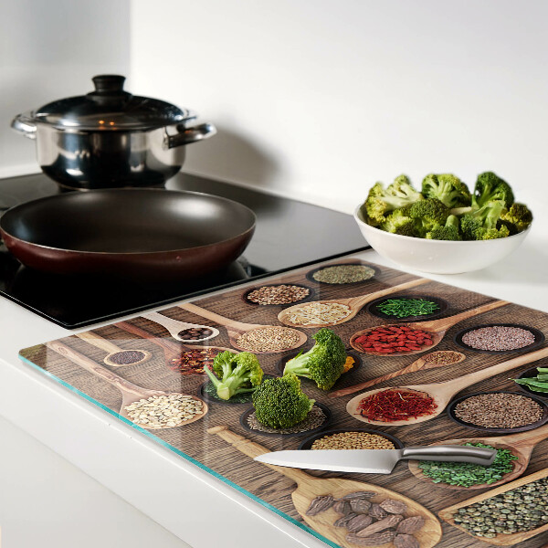 Glas schneidebrett Gewürze und Kräuter in Löffeln