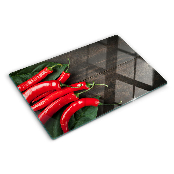 Glas-Schneidebrett mit Chilischoten auf Holzgrund