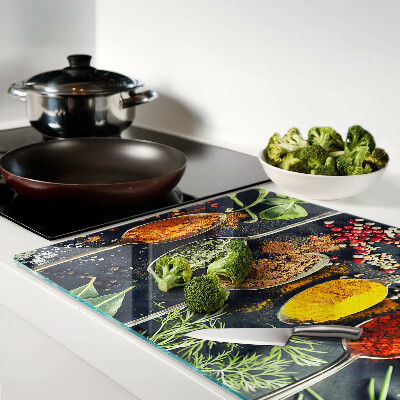 Glas-Schneidebrett mit Motiv aus Gewürzen auf Löffeln