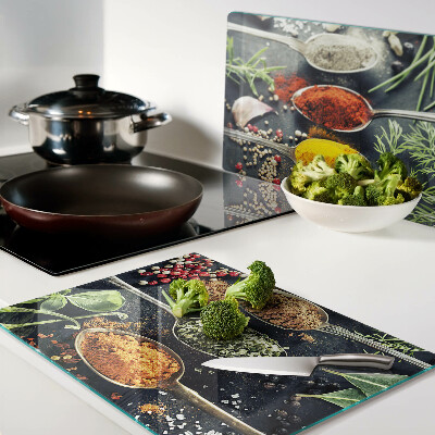 Glas-Schneidebrett mit Motiv aus Gewürzen auf Löffeln