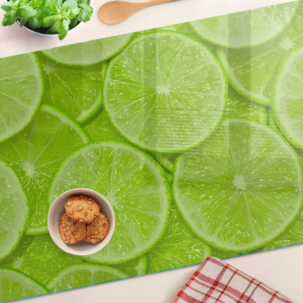 Schneidebrett Limettenscheiben auf grünem Hintergrund