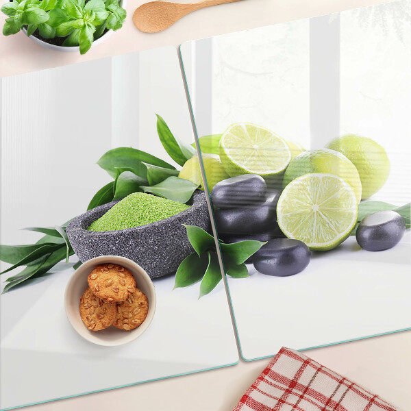 Glas-Schneidebrett mit Motiv aus Zitronen und Trauben auf grünem Hintergrund