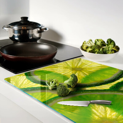 Schneidebrett mit Limettenscheiben auf grünem Hintergrund