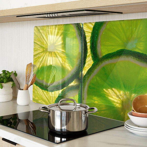 Schneidebrett mit Limettenscheiben auf grünem Hintergrund