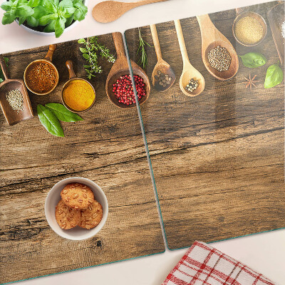 Schneidebrett mit Motiv aus Gewürzen und Kräutern auf Holzgrund